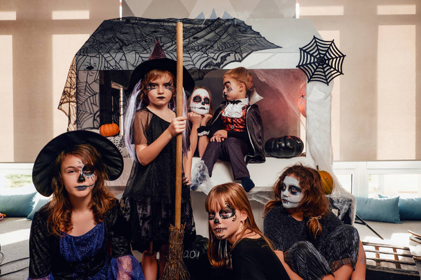 スタジオでの暗いハロウィンの衣装の子供たちのグループ - 写真・画像