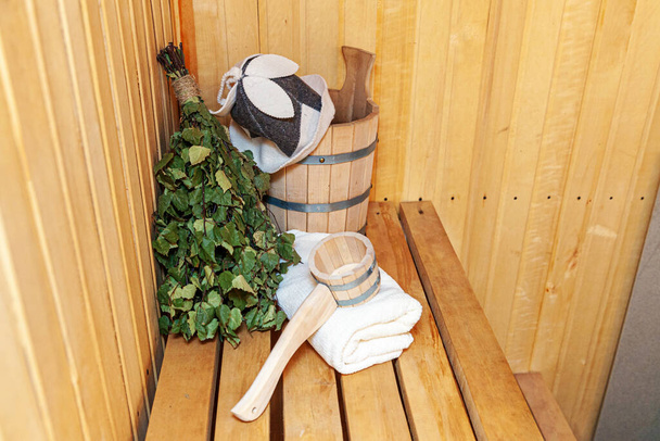 Détails intérieurs sauna finlandais hammam avec accessoires de sauna traditionnels lavabo bouleau balai scoop feutre chapeau serviette. Ancien bain traditionnel russe SPA Concept. Détendez-vous village de campagne bain concept - Photo, image