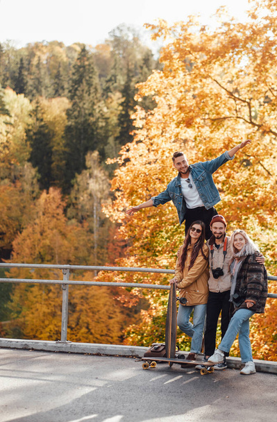 Carefree friends having a good time in autumn forest - Φωτογραφία, εικόνα