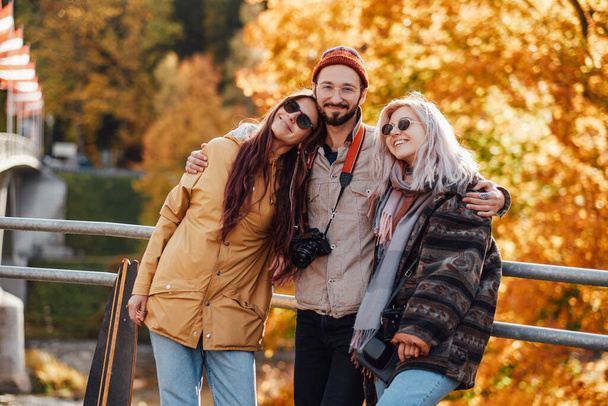 Groupe de trois amis posant dans le parc d'automne - Photo, image