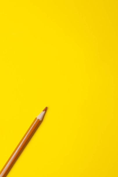 diagonal light brown sharp wooden pencil on a bright yellow background, isolated, copy space, mock up - Fotografie, Obrázek