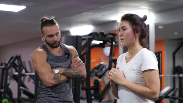 Gym-Unterricht mit einem jungen lustigen Trainer Mann Eine aufstrebende junge Frau stürzt sich - Filmmaterial, Video