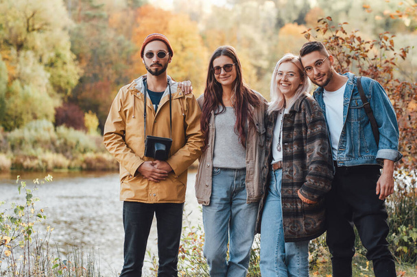 Společnost čtyř přátel procházejících se v podzimním lese - Fotografie, Obrázek