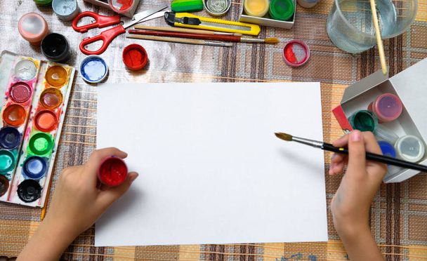 ein Mädchen zeichnet Aquarell auf ein leeres weißes Papier, künstlerisches Schaffen zu Hause, macht kreative Kunstwerke - Foto, Bild