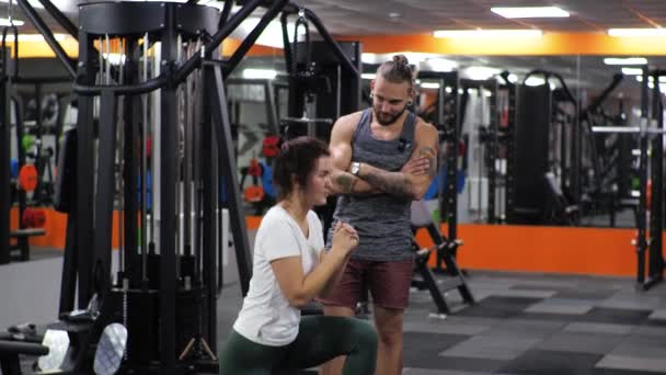 Gym Lesson egy fiatal vicces edző férfi Egy törekvő fiatal nő tüdő - Felvétel, videó