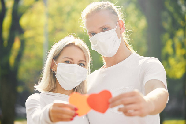 Couple with red heart wearing protective masks during coronavirus and flu outbreak. Virus and illness protection.  - Valokuva, kuva