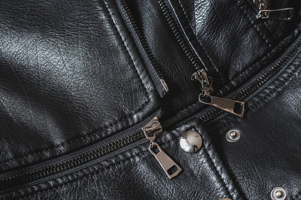 Fermeture éclair en métal sur une veste noire pour femme. Partie d'une veste en cuir, vue de dessus. Texture noire de cuir véritable - Photo, image