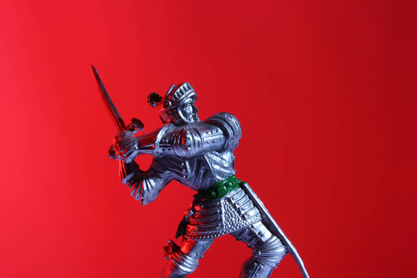 juguete caballero medieval sobre fondo rojo - Foto, imagen
