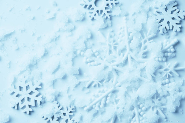 Fond de Noël avec espace de copie fait de flocons de neige et de neige sur fond bleu pastel. Concept d'hiver. Pose plate, vue du dessus, espace de copie - Photo, image