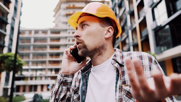 Engineer talking on phone. Architect using phone on construction site. Foreman phone call control process. Construction worker communications in construction industry. Building professional phone. - Photo, Image