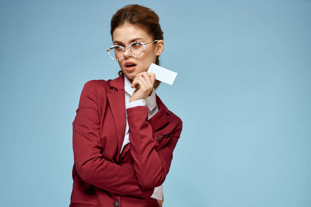 Femme d'affaires veste rouge lunettes de carte de visite exécutif fond bleu - Photo, image