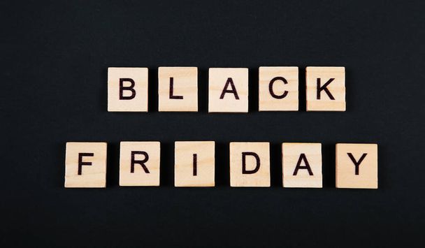 Black Friday, sale message, sign. Black friday sale poster or banner. Wooden letters on black background.  - Photo, Image