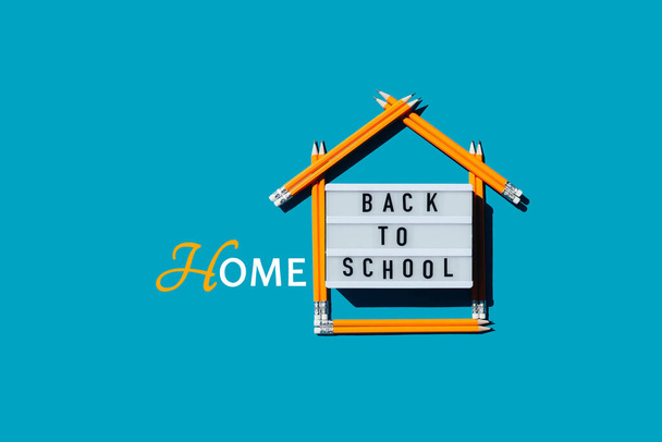Lightbox com a inscrição de volta para casa escola e uma casa feita de lápis.  - Foto, Imagem