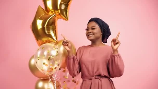 Fiesta musulmana de año nuevo con globos de oro para mujer negra. Africana chica atractiva celebración de fin de año. Emoción feliz - Metraje, vídeo