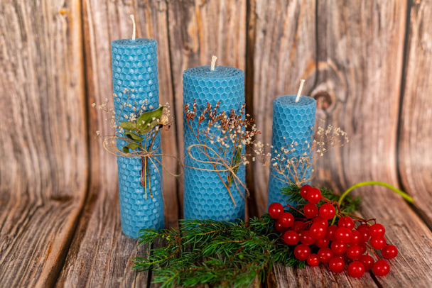 Blue honey candles handmade from natural wax on a background of wooden boards. Elements from natural materials. Christmas or New Years composition. Photo for postcards. - Photo, Image
