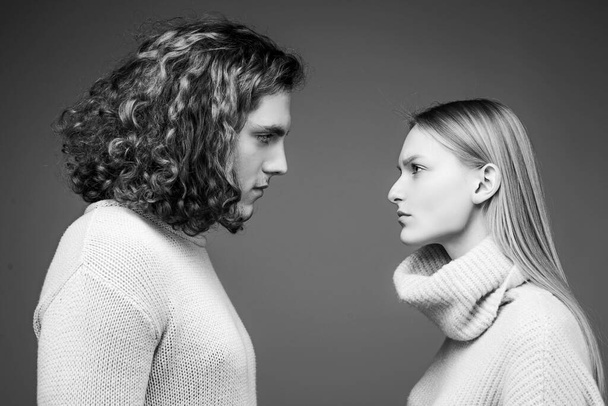 Side view. Curly man and blonde woman facing each other, eyes open. Concept of confrontation in the family. Boyfriend and girlfriend hating each other. - Foto, afbeelding