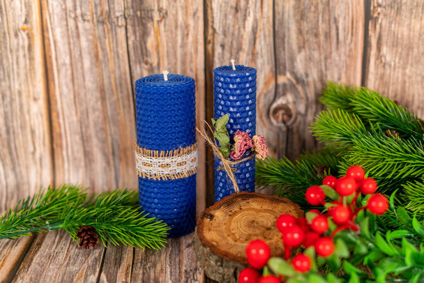 Blaue Honigkerzen handgefertigt aus natürlichem Wachs auf einem Hintergrund aus Holzbrettern. Elemente aus natürlichen Materialien. Weihnachts- oder Neujahrskomposition. Foto für Postkarten. - Foto, Bild