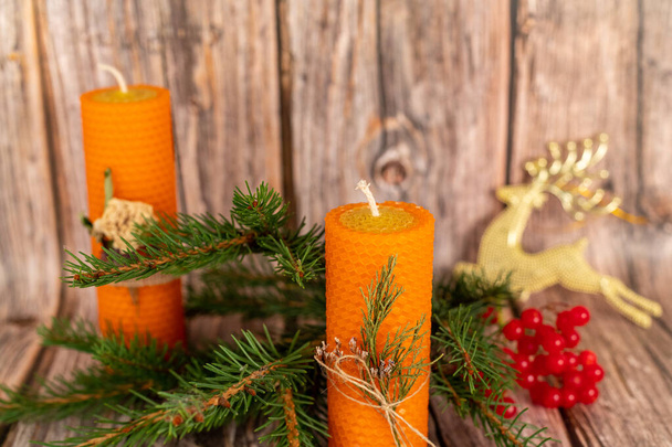 Orange honey candles handmade from natural wax on a background of wooden boards. Elements from natural materials. Christmas or New Years composition. Photo for postcards. - Photo, Image