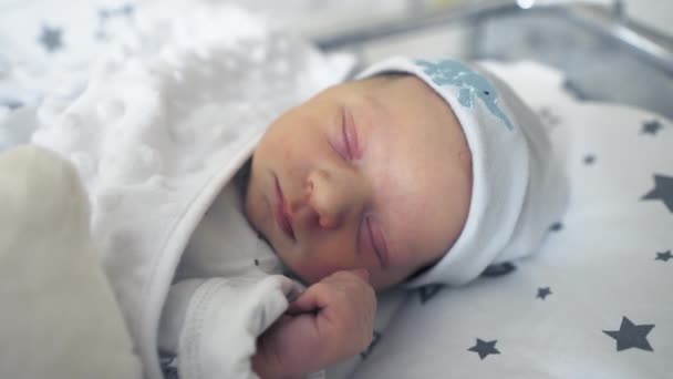 Imádnivaló újszülött békében alszik a kiságyában a kórházi szobában.  - Felvétel, videó