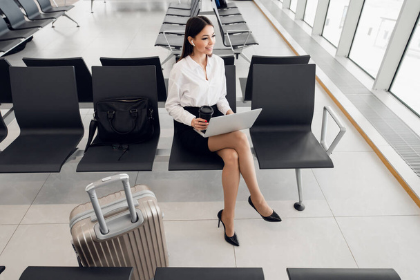 Jovem mulher de negócios elegante trabalhando com seu laptop no aeroporto - Foto, Imagem