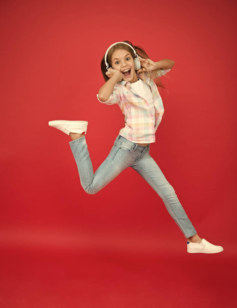 Jumping mid air. Happy small girl dancing. Cute child enjoying happy dance music. Music is happiness for her. Easy listening music. Small girl listening to music in headphones. Dancing girl - Фото, зображення