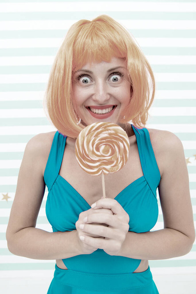 Cool girl with lollipop. Sexy woman. Fashion girl with orange hair having fun. happy pinup model with lollipop in hand. Crazy girl in playful mood. dieting. Sweet look. Enjoying sweet lollipop - Foto, imagen