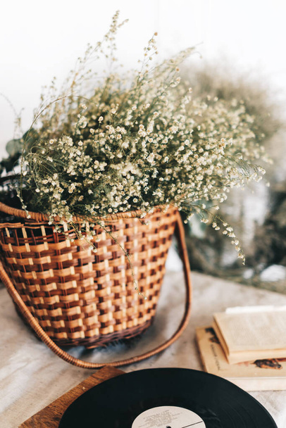 Wicker basket with dried flowers bouquet on the table. High quality photo - Fotografie, Obrázek