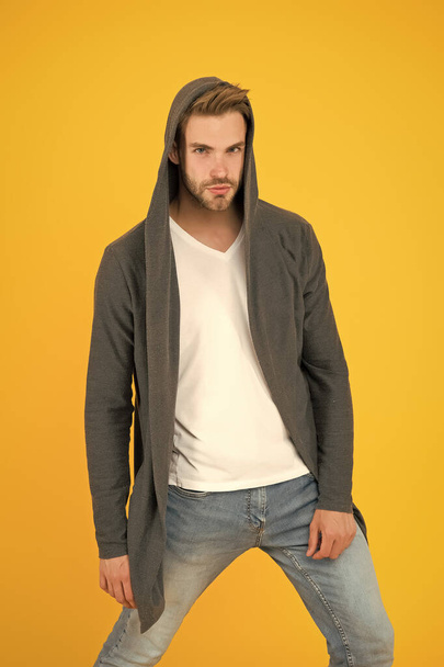 Casual menswear. Freedom of movement. Fashion trends. Modern clothes for youth. Sporty style. Fashion man yellow background. Fashion look. Handsome guy wear fashionable mantle with hood - Foto, afbeelding