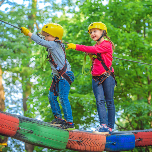 Hike and kids concept. Child boy having fun at adventure park. Climber child. Climber child on training. Kids boy adventure and travel. Happy Little child climbing a tree. - Photo, Image