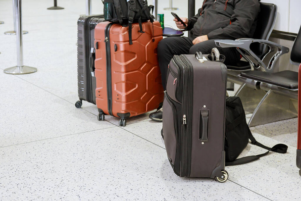 Zajęty człowiek na telefon na lotnisku na walizkach w poczekalni odlotów na lotnisku - Zdjęcie, obraz