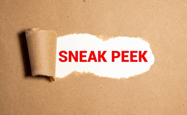 La frase Sneak Peek appare dietro carta marrone strappata - Foto, immagini