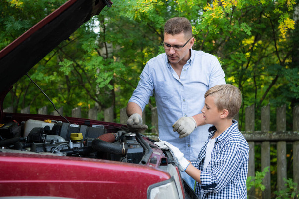 Papà e suo figlio riparare auto con cappuccio aperto all'aperto, il motore di fissaggio - Foto, immagini