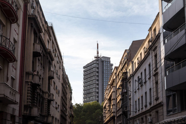 Старі житлові будівлі виконані з бетону і висотних сталевих хмарочосів 70-х років у центрі міста Белград, столиці Сербії, під час сонячного пополудня. - Фото, зображення