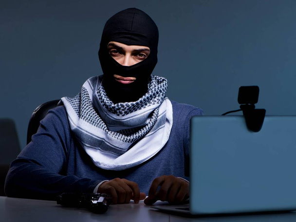 バラクラバマスクを身に着けているハッカーはコンピュータをハッキング - 写真・画像