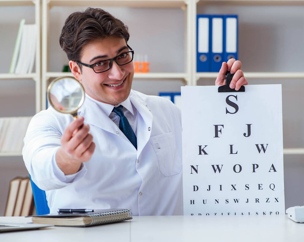 Doctor optician with letter chart conducting an eye test check - Photo, Image