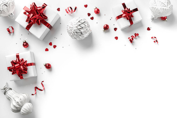 Wesołych Świąt kartka wykonana z pudełek, czerwony i srebrny dekoracji, musujące i confetti na białym tle. Święta Bożego Narodzenia i Nowy Rok wakacje, bokeh, światło. Płaskie ułożenie, widok z góry, ramka - Zdjęcie, obraz