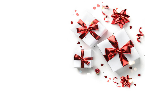 Boldog karácsonyi lapot készült ajándékdobozok, piros dekoráció, csillogás és konfetti fehér alapon. Karácsony és újév ünnepe, bokeh, könnyű. Lapos fekvésű, felülnézet - Fotó, kép