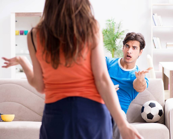 A feleség boldogtalan, hogy a férj focit néz. - Fotó, kép