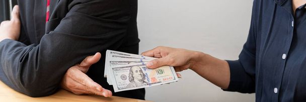 Empresario que recibe billetes de dólares estadounidenses a la corrupción de su socio en los negocios en el escritorio de trabajo - concepto de soborno - Foto, Imagen