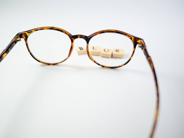 Brille und ein Buchstabenblock, der BLUR liest, Klare Sicht auf Brillengläsern - Foto, Bild