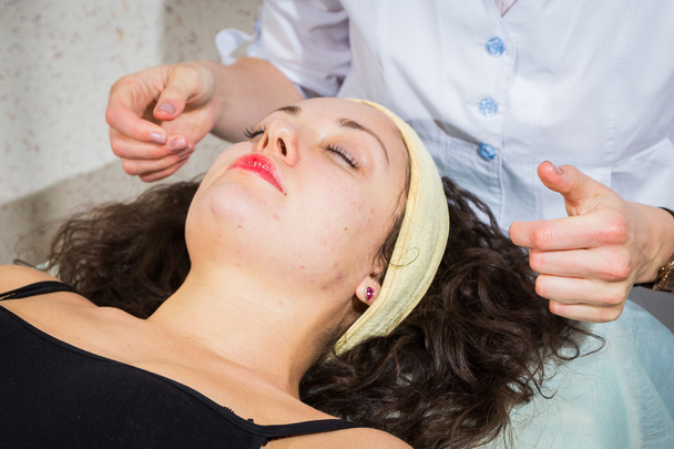 žena přijímá masáž obličeje se zavřenýma očima v centru - Fotografie, Obrázek