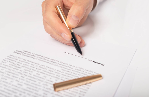 Contract signing concept. Businessman hand with pen over document, space for signature, closeup. - Фото, изображение