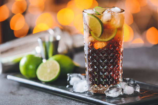 Glass of tasty Cuba Libre cocktail on table - 写真・画像