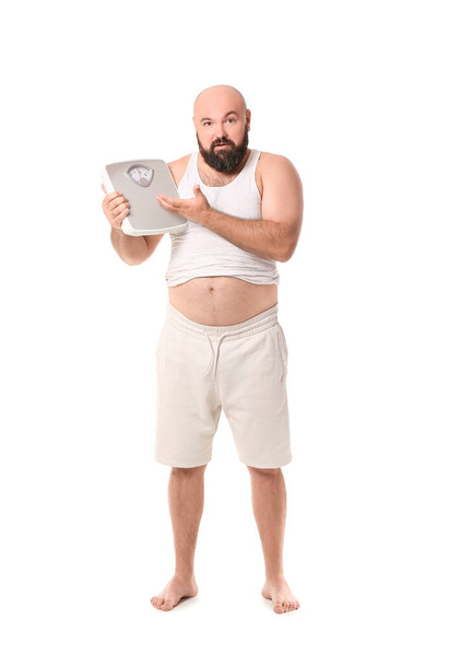 Overweight man with scales on white background. Weight loss concept - Zdjęcie, obraz