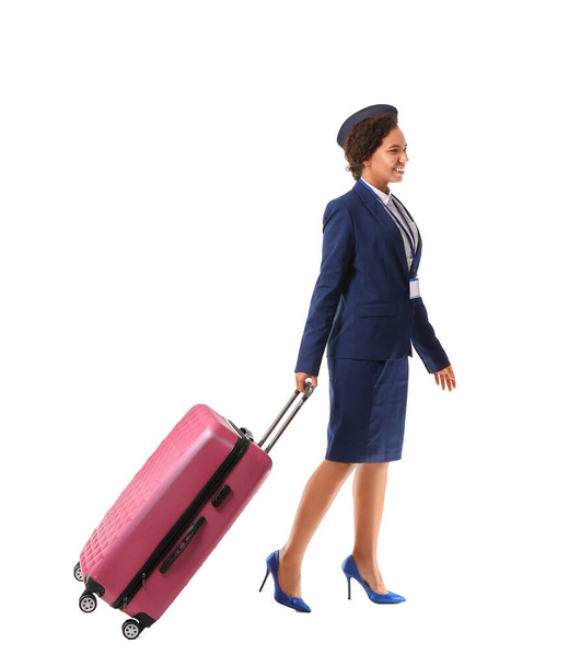Beautiful African-American stewardess with luggage on white background - Foto, Imagem
