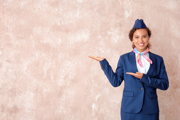Красивая афроамериканская стюардесса на цветном фоне - Фото, изображение