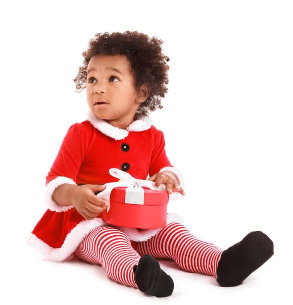 Aranyos afro-amerikai kislány öltözött Mikulás és karácsonyi ajándék fehér háttér - Fotó, kép