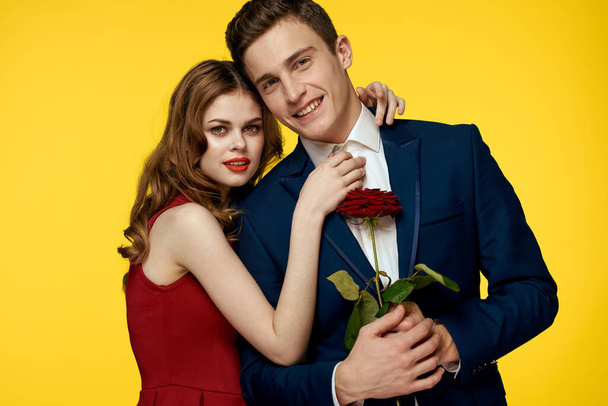 Giovane coppia affascinante rosa relazione romanticismo dono come uno stile di vita giallo sfondo isolato - Foto, immagini