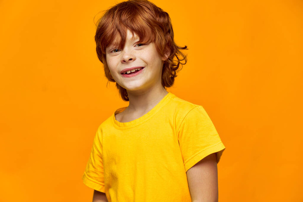 Експресивний хлопчик з рудим волоссям ізольований фон красива посмішка жовта футболка
  - Фото, зображення