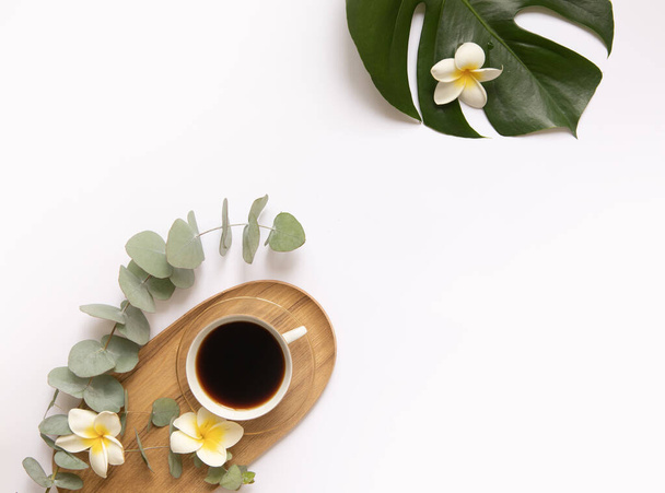 Cup of black coffee with fresh tropical leaves. - Photo, Image